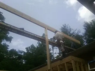 Carpenter setting a ridge beam over a new addition frame — Ice Dam Removal by Roofing Brothers in Glasgow