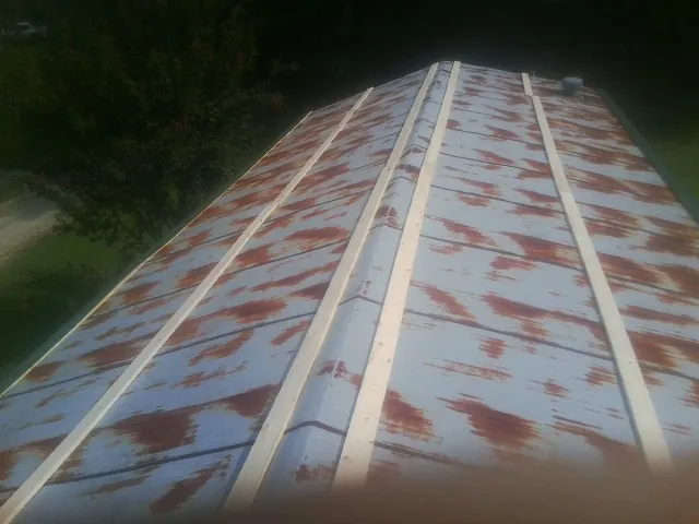 Rusted metal roof panels with new wood purlins before replacement — Storm Damage Roof Repair in Glasgow by Roofing Brothers