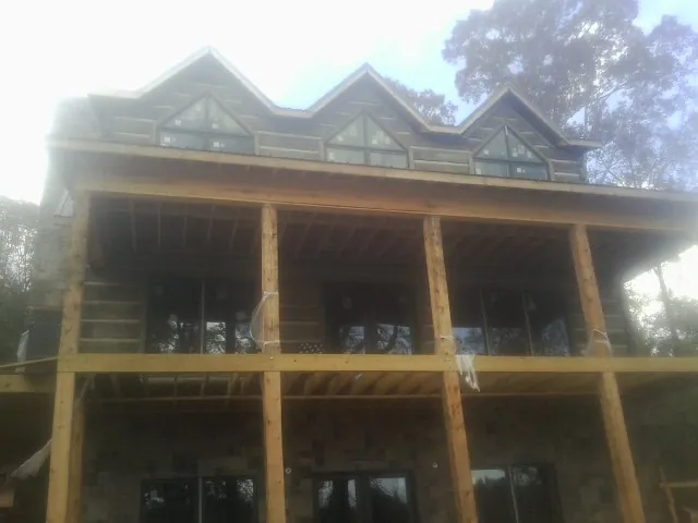 Dormers and porch framing on a large log home under construction — Roof Coating work by our crew in Glasgow