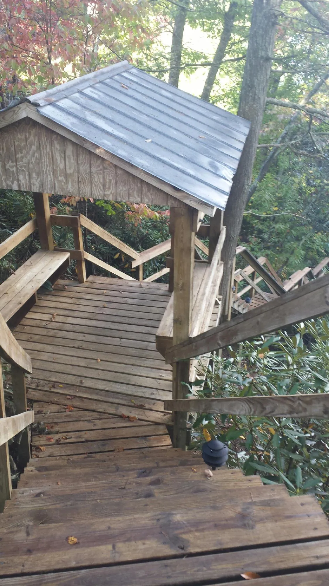 Metal roofed shelter over wooden steps on a wooded walkway — Skylight Repair & Installation work by our crew in Glasgow