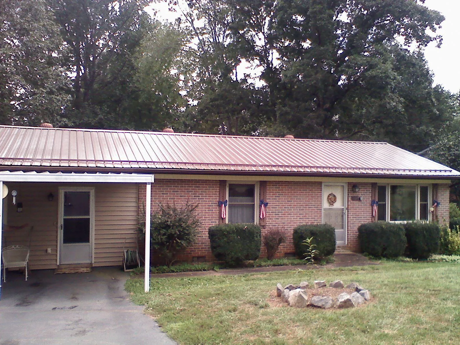 Bronze metal roof and carport on a brick ranch home — Roof Repair work by our crew in Glasgow