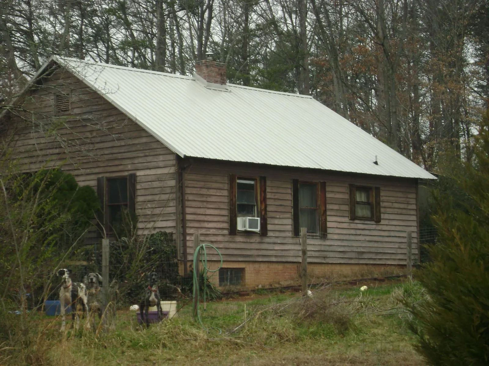 White metal roof on an old wood sided farmhouse, from a Metal Roof Installation job in Glasgow